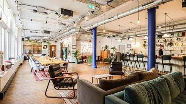 FutureKings Amsterdam office showing sofas, desks and a bar.